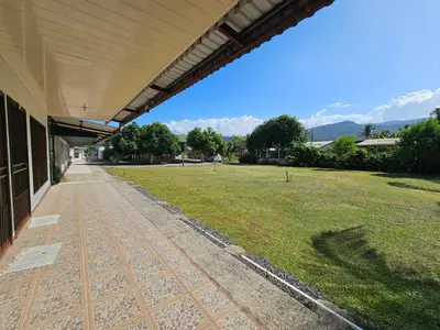 a building with a grass field next to a building at Sleep&Go! Apartamento 2 habitaciones 4 personas Siquirres centro in Siquirres