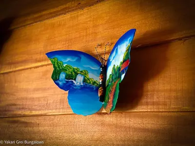 a butterfly is hanging on a wall at Bungalows Yakari Grei in San Ramón