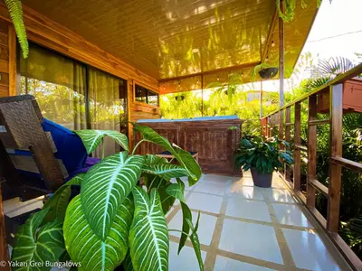 a balcony with plants and a table and chairs at Bungalows Yakari Grei in San Ramón