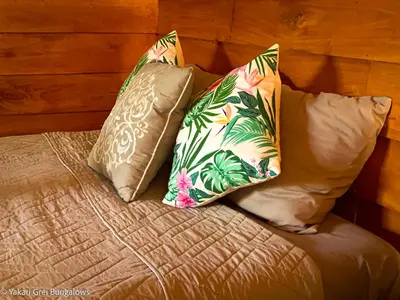 a bed with two pillows on top of it at Bungalows Yakari Grei in San Ramón