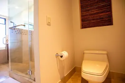 a bathroom with a toilet and a glass shower at Adults Only 4BR Penthouse w Partial Ocean View, Carao Reserva Conchal in Playa Conchal