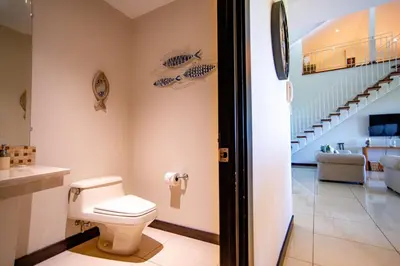 a bathroom with a toilet and a staircase at Adults Only 4BR Penthouse w Partial Ocean View, Carao Reserva Conchal in Playa Conchal