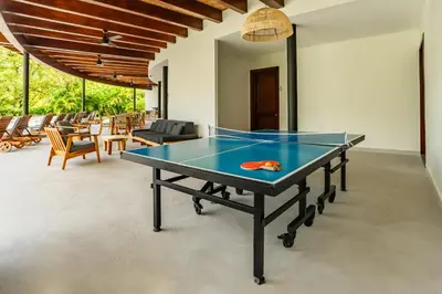 a ping pong table in the middle of a room at Adults Only 4BR Penthouse w Partial Ocean View, Carao Reserva Conchal in Playa Conchal
