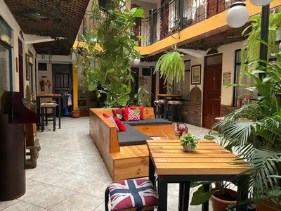 a patio with a couch and tables and plants at Hotel Amón Real Costa Rica in San José