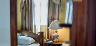 a bedroom with a bed with a lamp and a window at Hotel Amón Real Costa Rica in San José