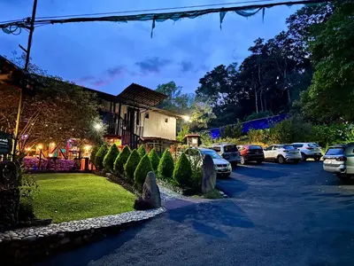 a parking lot with cars parked in front of a house at Hotel de Montaña El Pelicano in San Isidro