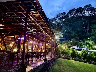 an outdoor restaurant with tables and chairs at night at Hotel de Montaña El Pelicano in San Isidro