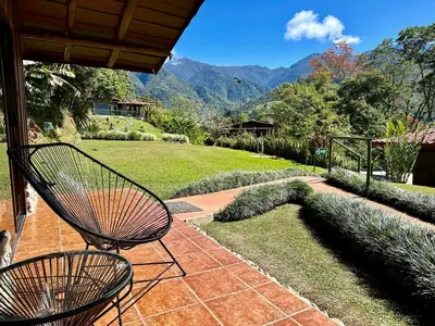 a patio with two chairs and a view of the mountains at Hotel de Montaña El Pelicano in San Isidro