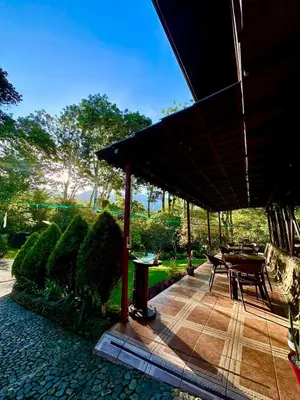 a patio with a table and chairs under a roof at Hotel de Montaña El Pelicano in San Isidro
