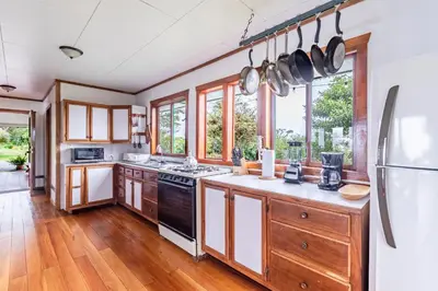 a kitchen with wooden cabinets and black appliances at Refugio San Antonio - 1500 acre Private Preserve in Guaria