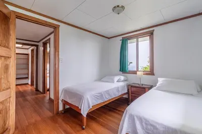 a bedroom with two beds and a window at Refugio San Antonio - 1500 acre Private Preserve in Guaria