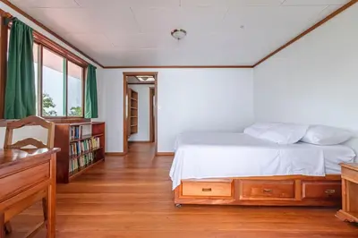 a bedroom with a bed and a book shelf at Refugio San Antonio - 1500 acre Private Preserve in Guaria
