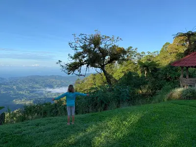 a girl standing on a hill with her arms outstretched at Refugio San Antonio - 1500 acre Private Preserve in Guaria