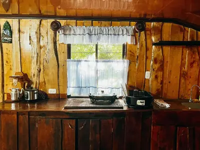 a kitchen with a counter top with a window at Cabaña Piqueza! in Poás