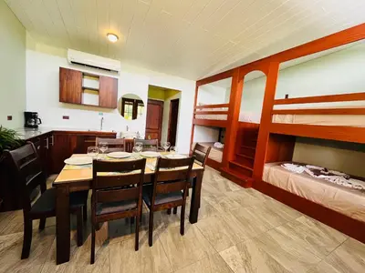 a dining room with a table and chairs and bunk beds at The Wellness Park Costa Rica in Fortuna