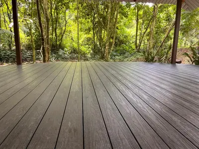 a wooden deck with trees in the background at The Wellness Park Costa Rica in Fortuna