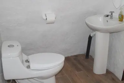 a bathroom with a white toilet and a sink at The Wellness Park Costa Rica in Fortuna