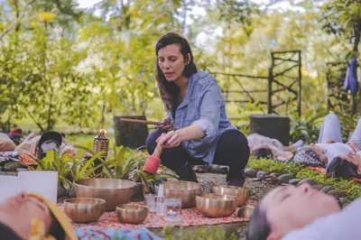 a woman sitting on the ground with plants in pots at The Wellness Park Costa Rica in Fortuna