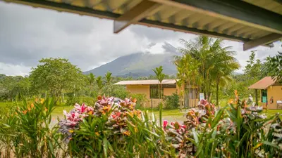a view of a mountain from a house with flowers at The Wellness Park Costa Rica in Fortuna