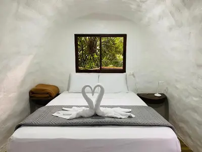 two white swans sitting on a bed in a room at The Wellness Park Costa Rica in Fortuna