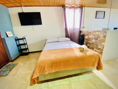 a bedroom with a bed and a tv on the wall at Nomads Family Rooms, Fortuna Town in Fortuna