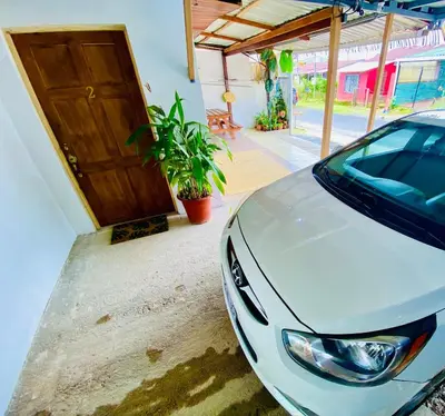 a white car parked in front of a door at Nomads Family Rooms, Fortuna Town in Fortuna