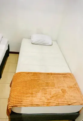 a bed in a room with a pillow on it at Nomads Family Rooms, Fortuna Town in Fortuna
