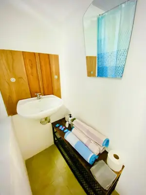 a bathroom with a sink and a mirror and towels at Nomads Family Rooms, Fortuna Town in Fortuna