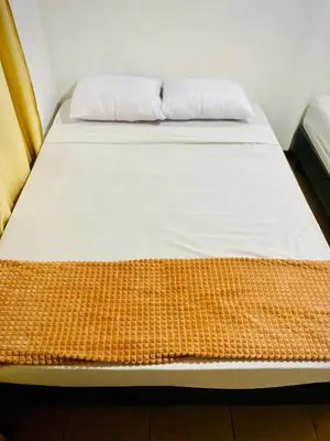a bed with two pillows on it in a room at Nomads Family Rooms, Fortuna Town in Fortuna