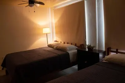 a bedroom with two beds and a ceiling fan at La casa del volcán in Fortuna