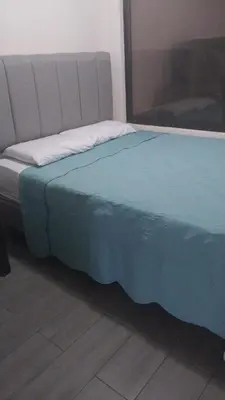 a bed in a room with a blue blanket on it at La casa del volcán in Fortuna