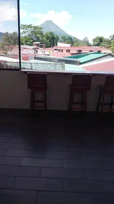 two chairs sitting at a bar on a roof at La casa del volcán in Fortuna