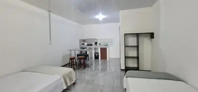 a white room with two beds and a table at Sleep&Go! Cabina Familiar con 5 camas - Siquirres centro in Siquirres