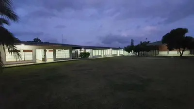 a building with a large yard in front of it at Sleep&Go! Cabina Familiar con 5 camas - Siquirres centro in Siquirres
