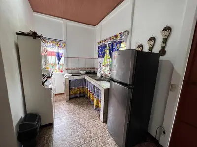 a kitchen with a stainless steel refrigerator in a room at Natural Experience House in Tortuguero