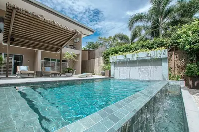 a swimming pool in the backyard of a house at Tamarindo Bay Boutique Hotel, Apartments & Suites in Tamarindo