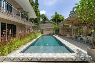 a swimming pool in the backyard of a house at Tamarindo Bay Boutique Hotel, Apartments & Suites in Tamarindo