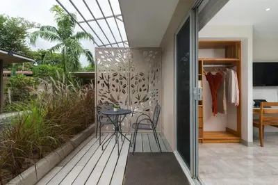 a small balcony with a table and chairs on it at Tamarindo Bay Boutique Hotel, Apartments & Suites in Tamarindo