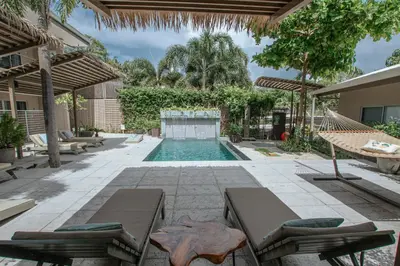 a backyard with a swimming pool and a resort at Tamarindo Bay Boutique Hotel, Apartments & Suites in Tamarindo