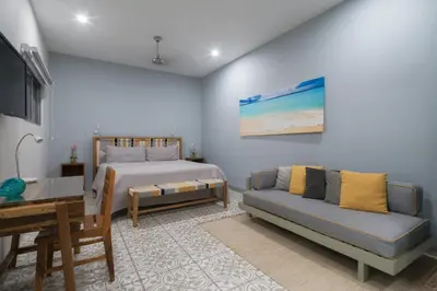 a bedroom with a bed and a couch and a desk at Tamarindo Bay Boutique Hotel, Apartments & Suites in Tamarindo