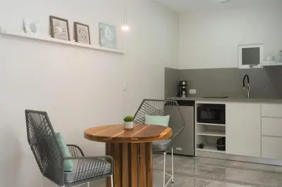 a kitchen with a wooden table and chairs in a room at Tamarindo Bay Boutique Hotel, Apartments & Suites in Tamarindo
