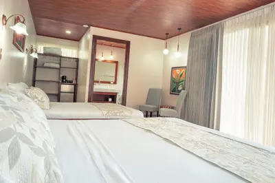 a bedroom with two beds and a window at Miradas Arenal Hotel & Hotsprings in Fortuna