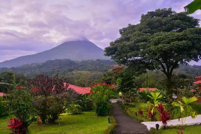 a mountain in the distance with a road and trees at Miradas Arenal Hotel & Hotsprings in Fortuna