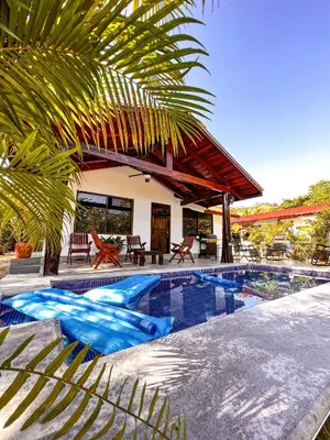 a villa with a swimming pool and a house at Casa Los Ninos in Sámara