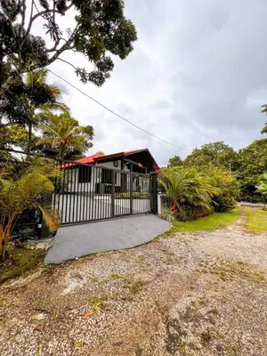 a house with a white fence and a driveway at Casa Los Ninos in Sámara