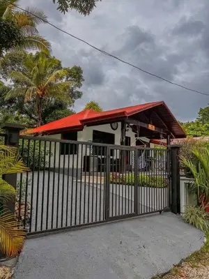 a house with a gate and a red roof at Casa Los Ninos in Sámara