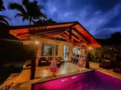 a villa with a swimming pool and a house at Casa Los Ninos in Sámara