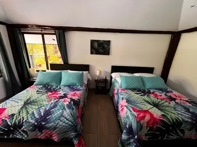 a bedroom with two beds and a window at Casa Los Ninos in Sámara