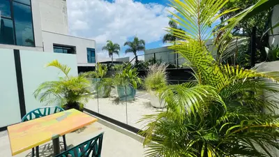 a patio with palm trees and a table and chairs at Cozy apartment with terrace, SJ Cosmopolitan Tower #402 in San José