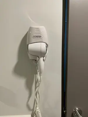 a hair dryer is hanging on a wall at Cozy apartment with terrace, SJ Cosmopolitan Tower #402 in San José